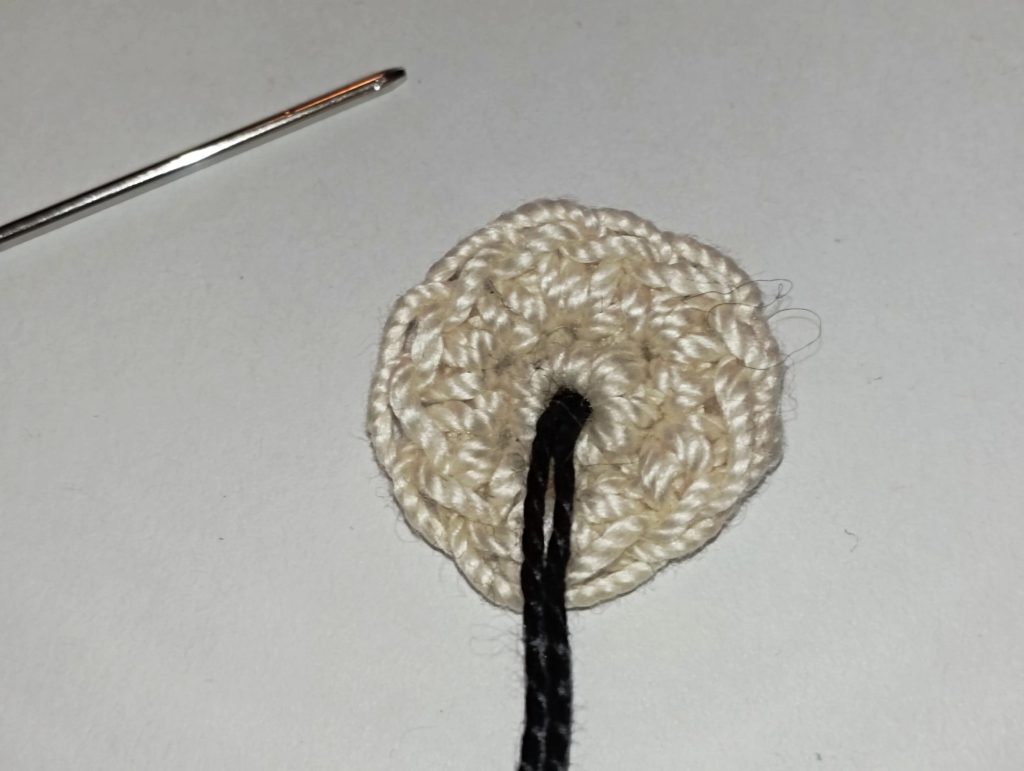 broder l'oeil du niffleur : phase 1 - passer le fil de coton noir par le centre du rond crocheté