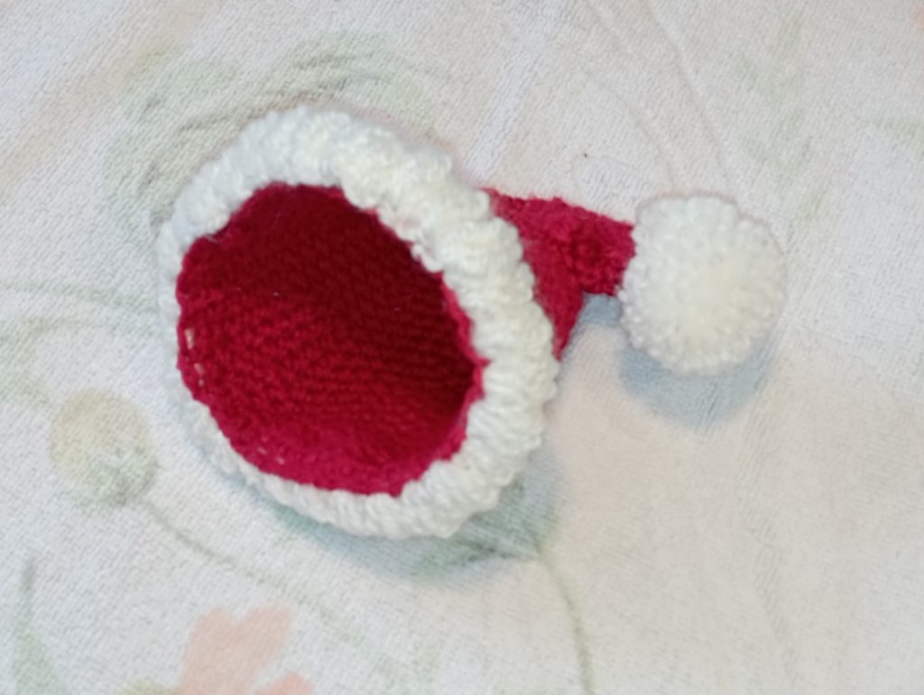 plumpy christmas gnome : le bonnet est terminé avec un pompon et un bord de fourrure blanche